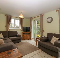 A living room with a sofa and television at Orchard Cottage Corse near Gloucester