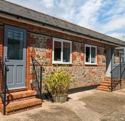 An exterior view of a building with steps and a planter at The Milk Shed Plymtree