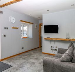 A living room with a sofa and television at The Milk Shed in Plymtree