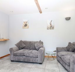 A living room with two sofas and a TV at The Milk Shed in Plymtree