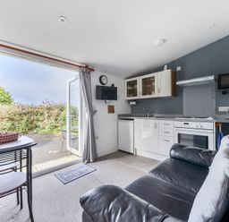 A kitchen with a seating area at The Nook in Praa Sands