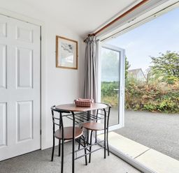 A dining area with a table and chairs at The Nook in Praa Sands