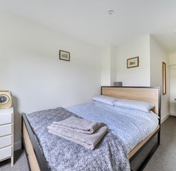 A bedroom with a bed and dresser at The Nook in Praa Sands