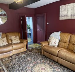 A living room with sofas and a mirror at High Dyke Cottage