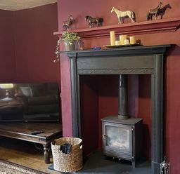 A living room with a television and fireplace at High Dyke Cottage