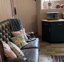 A kitchen with a sofa and countertop appliances at High Dyke Cottage