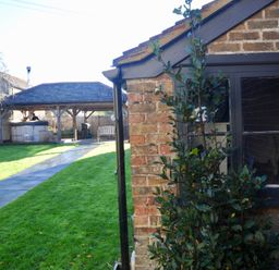 A garden with a brick wall and pathway at ASH HOUSE in Wincanton