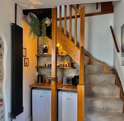 A hallway with a staircase and kitchen appliances at 