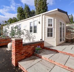An outdoor area with a house and seating at Lodge in Talacre