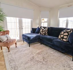 A living room with a sofa and a chair at Lodge in Talacre