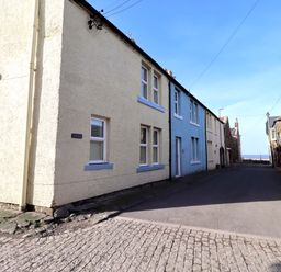A street view showing buildings and flower pots at Corner Cottage in Seahouses