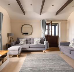 A living room with a sofa and ottoman at The Granary, Engollan near St Merryn