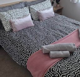 A bed with decorative pillows and towels at an unspecified location