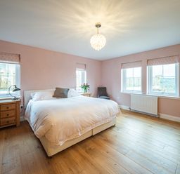 A bedroom with a bed and side table at a property