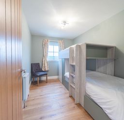 A bedroom with a bunk bed and chair at the property in location