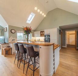 A kitchen with a bar, stove and television at The Old Barn in Manchester
