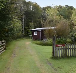 A path leading to a shed with a sign at Baillie Chalet
