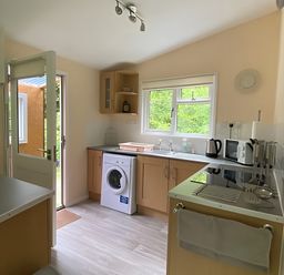 A kitchen with a washing machine and appliances at Baillie Chalet