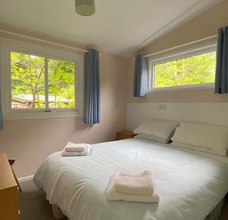 A bedroom with a bed and windows at Baillie Chalet