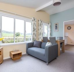 A living room with a sofa and dining area at The Old Barn in Manchester