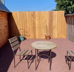 An outdoor seating area with a wooden table and chairs at location