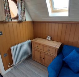 A corner with a radiator and a wooden cabinet at a property