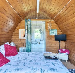 A bedroom with a bed and television at St Austell Glamping in St Austell