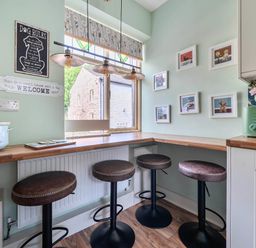 A kitchen with bar stools and a table at 20 Main Street in Heysham
