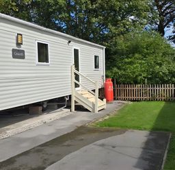 An outdoor area with a caravan and a lawn at Caravan