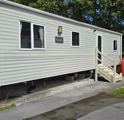A caravan with stairs and a gas cylinder at Coworth