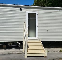 An entrance to a mobile home with steps at Caravan