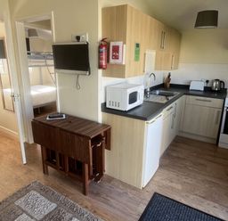 A kitchen area with appliances and a bedroom view at Embury 