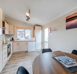A kitchen with cabinets and a dining table at 311 Bridlington