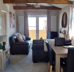 A living room with sofa and dining area at 50 Bridlington