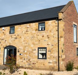 A stone and brick building with windows and a door at The Galloway in Morpeth
