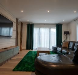 A living room with a sofa, coffee table, and television at The Galloway in Morpeth