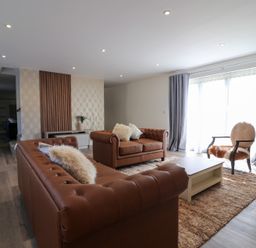 A living room with sofas and an armchair at The Newland in Morpeth