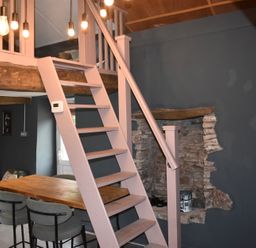 A dining area with stairs and lights at Ty Llaeth in Carmarthen