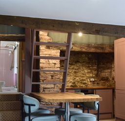 A kitchen with a staircase and stone wall at Ty Llaeth in Carmarthen