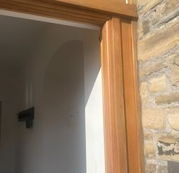A hallway with a wooden door and coat hooks at 4 Bickington Road Barnstaple