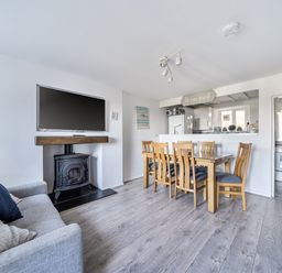 A living room with a television and dining area at Blue Haven in Penmaenmawr