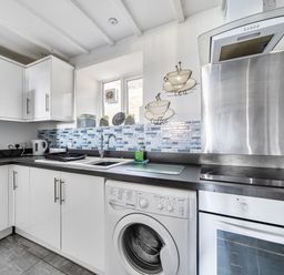 A kitchen with cabinets, sink, and appliances at Blue Haven in Penmaenmawr