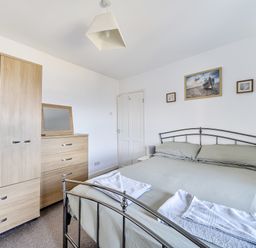 A bedroom with a bed, wardrobe, and drawers at Blue Haven in Penmaenmawr