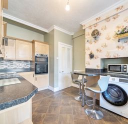 A kitchen with an oven, microwave, and washing machine at Sea View Escape, Penmaenmawr