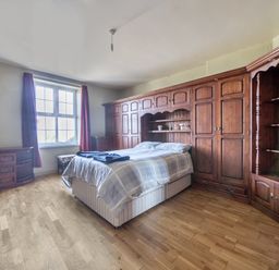A bedroom with a bed and wooden furniture at Sea View Escape in Penmaenmawr