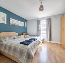 A bedroom with two beds and a wardrobe at Sea View Escape Penmaenmawr