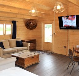 A living room with a sofa, table, and television at Cotswold Nights Away 1 in Evesham