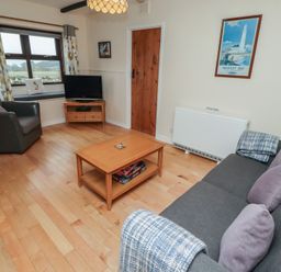 A living room with a sofa and television at Sunny Brae in Alnwick