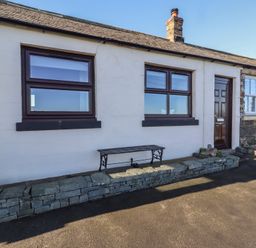 An exterior view of a cottage with windows and a door at 2 Sunny Brae Embleton