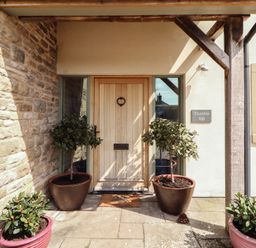 An entrance with a wooden door and planters at Thimble Hill Near Armathwaite